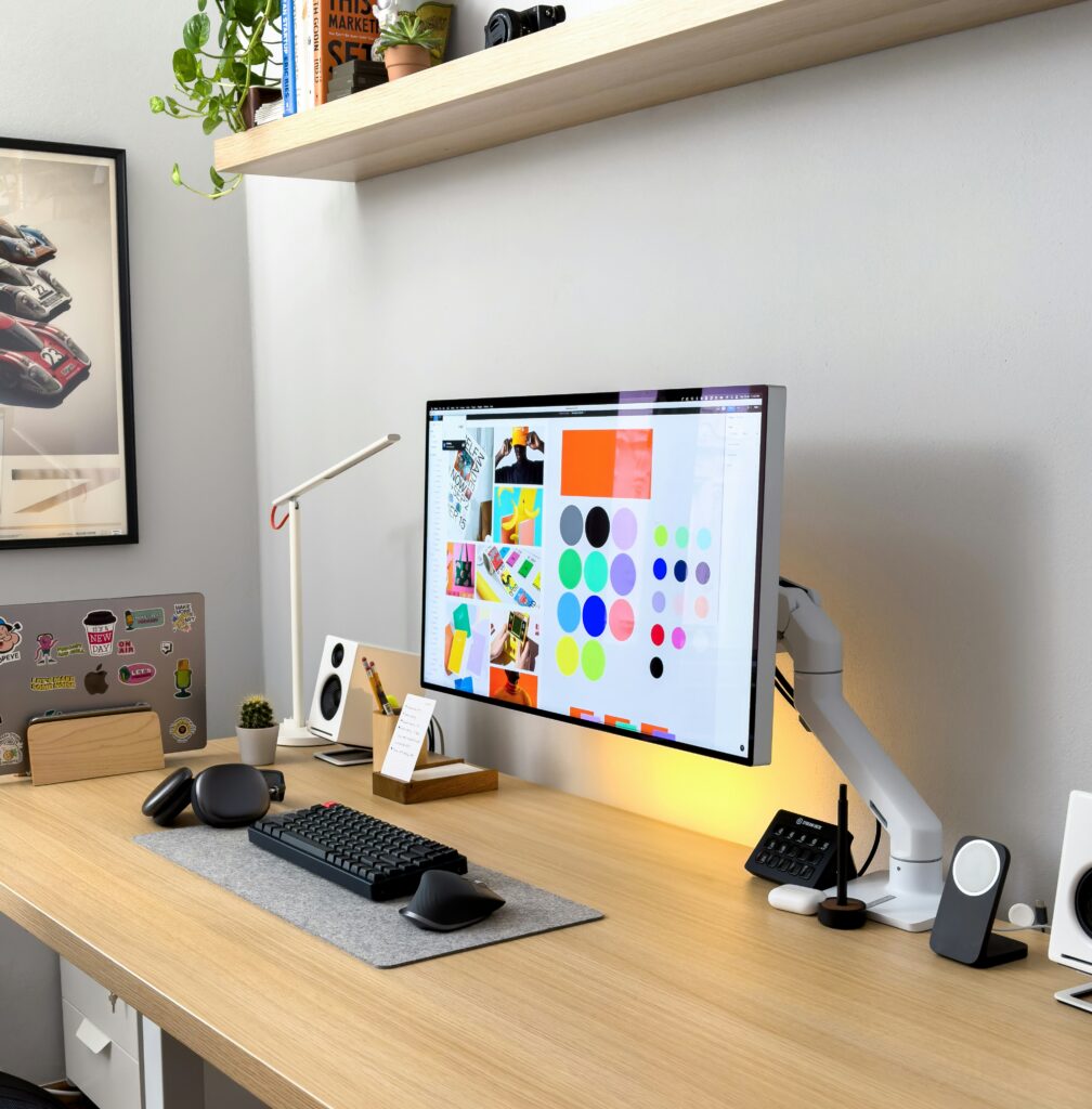 Designer workspace with a monitor showing brand colors and visual identity concepts
